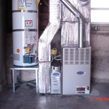 Image of a heating system with a furnace and water heater installed in a basement, showcasing the professional installation work by Schmitt Heating Company, Inc. in San Francisco.