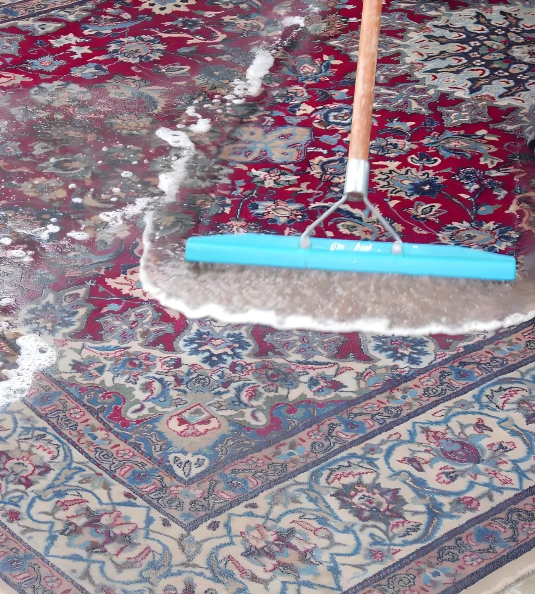A blue squeegee being used to clean a patterned rug with soap and water, showcasing Scotty Steam Clean’s carpet cleaning service in Santa Rosa.