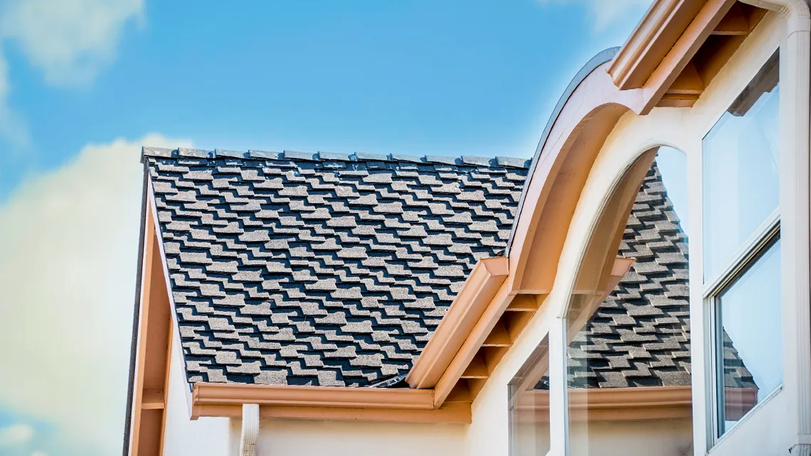 "Close-up view of a well-constructed roof with gray shingles and a decorative trim in Monterey, completed by Scudder Roofing Company."