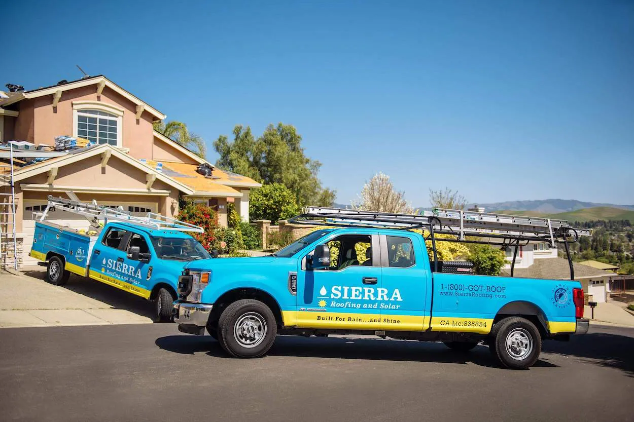 Two Sierra Roofing & Solar trucks parked in front of a house under construction in Dublin.