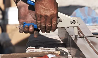 Close-up image of hands using tools for detailed roofing work, representing Sierra Roofing & Solar in Dublin.