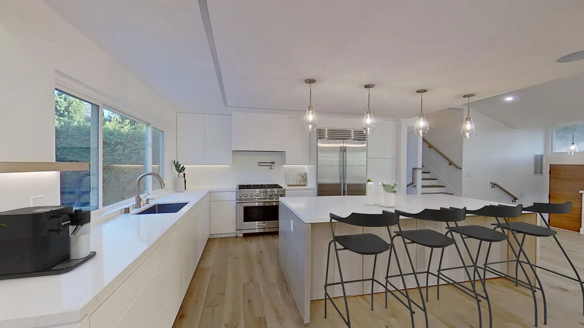 A modern kitchen in San Jose designed by Sigura Construction, Inc., featuring white cabinetry, stainless steel appliances, and a spacious island with barstools.