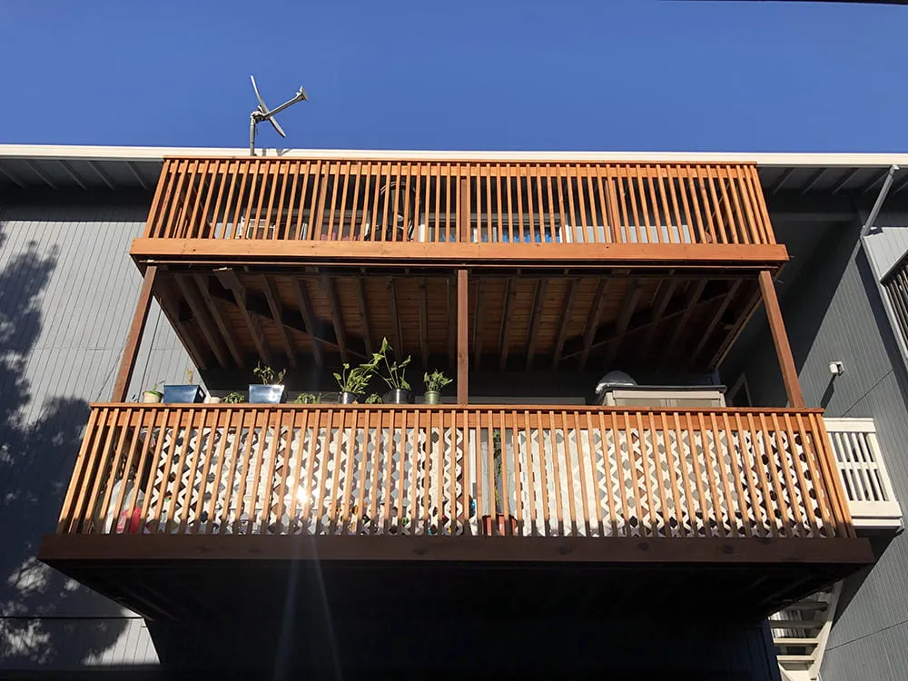 Two-tier wooden balcony with potted plants, designed and built by Simple Builders in Winnetka.