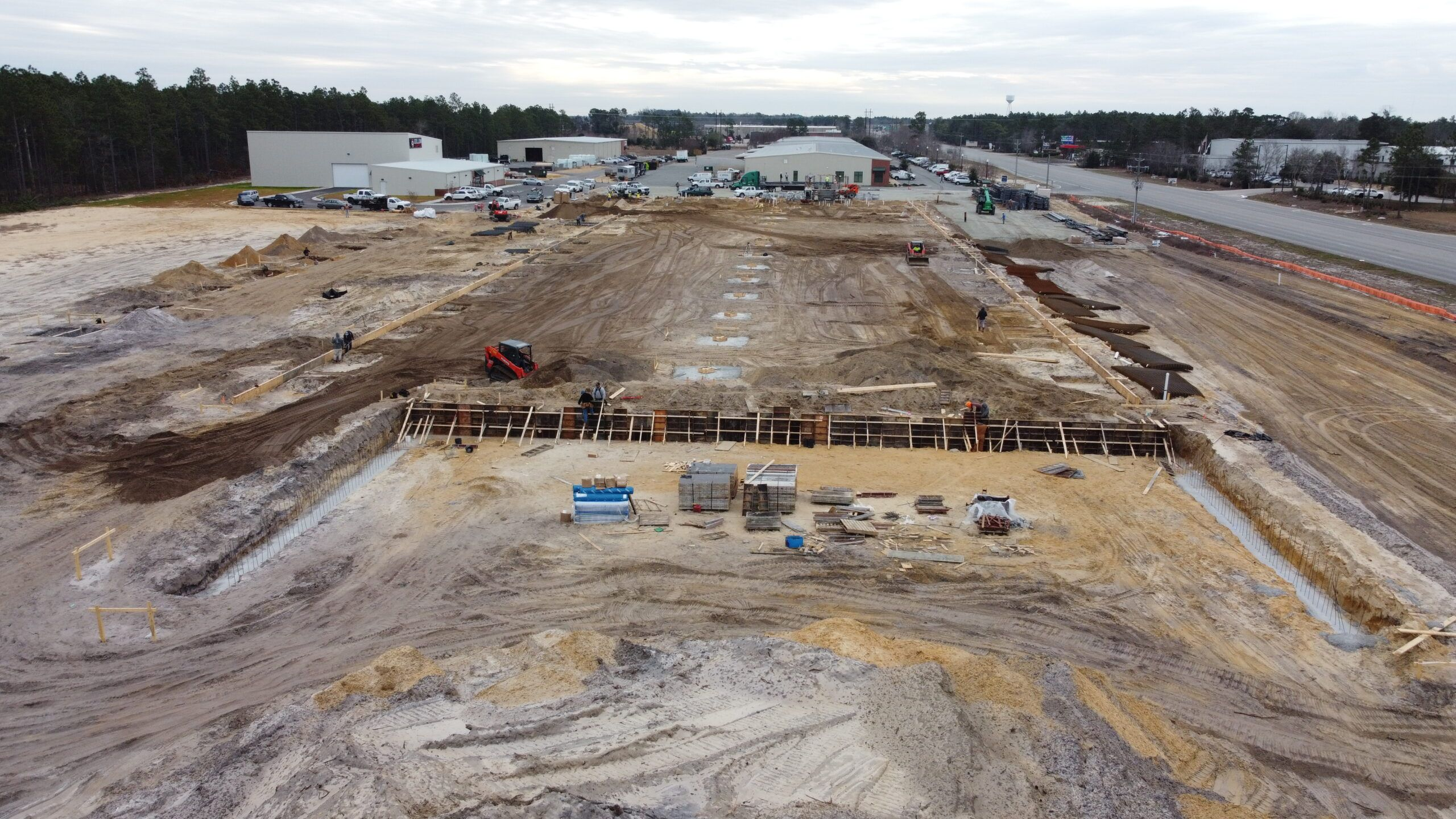 Construction site in Martinez showing early foundation work, with equipment and materials from Smith & Son Construction.