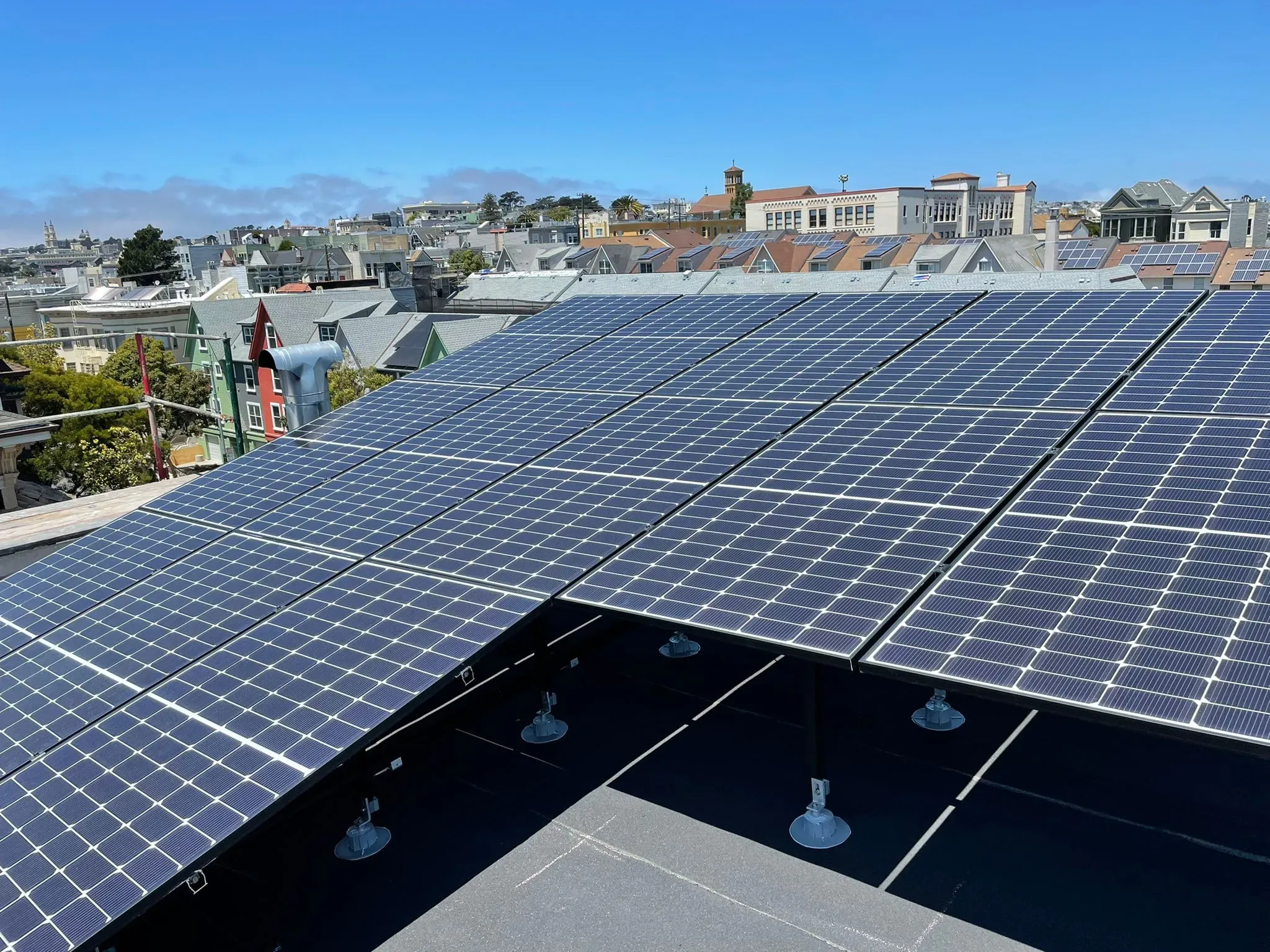 Rooftop solar panels installed in a residential area of San Francisco by SolarUnion, under a clear blue sky.
