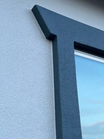 Close-up of a window frame with a dark blue trim against a light-colored wall, showcasing the precise painting work of Solidarity Painting, Inc. in Santa Rosa.