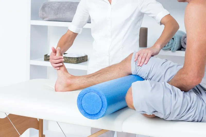 A person receiving leg therapy using a foam roller by a therapist at Springtown Wellness Center in Livermore.