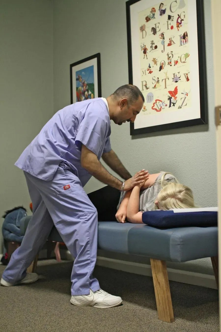 A chiropractor at Springtown Wellness Center in Livermore performing an adjustment on a patient lying on their side on a treatment table.