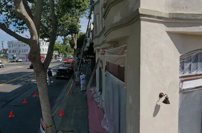 A team from Steve Roberts Painting works on the exterior of a building in Walnut Creek, with protective sheets and orange cones marking the area.