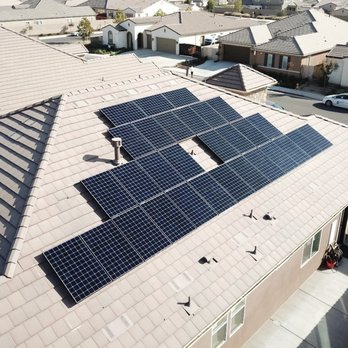 Residential rooftop with solar panels installed by SunMade Smart Roofing, Solar & Electric in Fresno neighborhood.