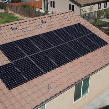 A roof in Fresno equipped with an array of solar panels, installed by SunMade Smart Roofing, Solar & Electric.