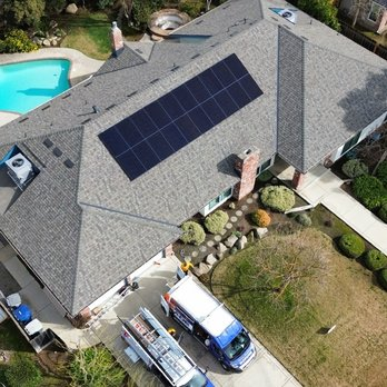 Aerial view of a house in Fresno with solar panels installed by SunMade Smart Roofing, Solar & Electric, with a pool and service vehicles visible.