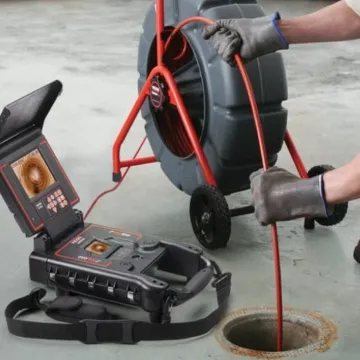 A plumber using a video inspection device to examine pipes, highlighting the services of Superior Plumbing & Drain Cleaning Services in Richmond.