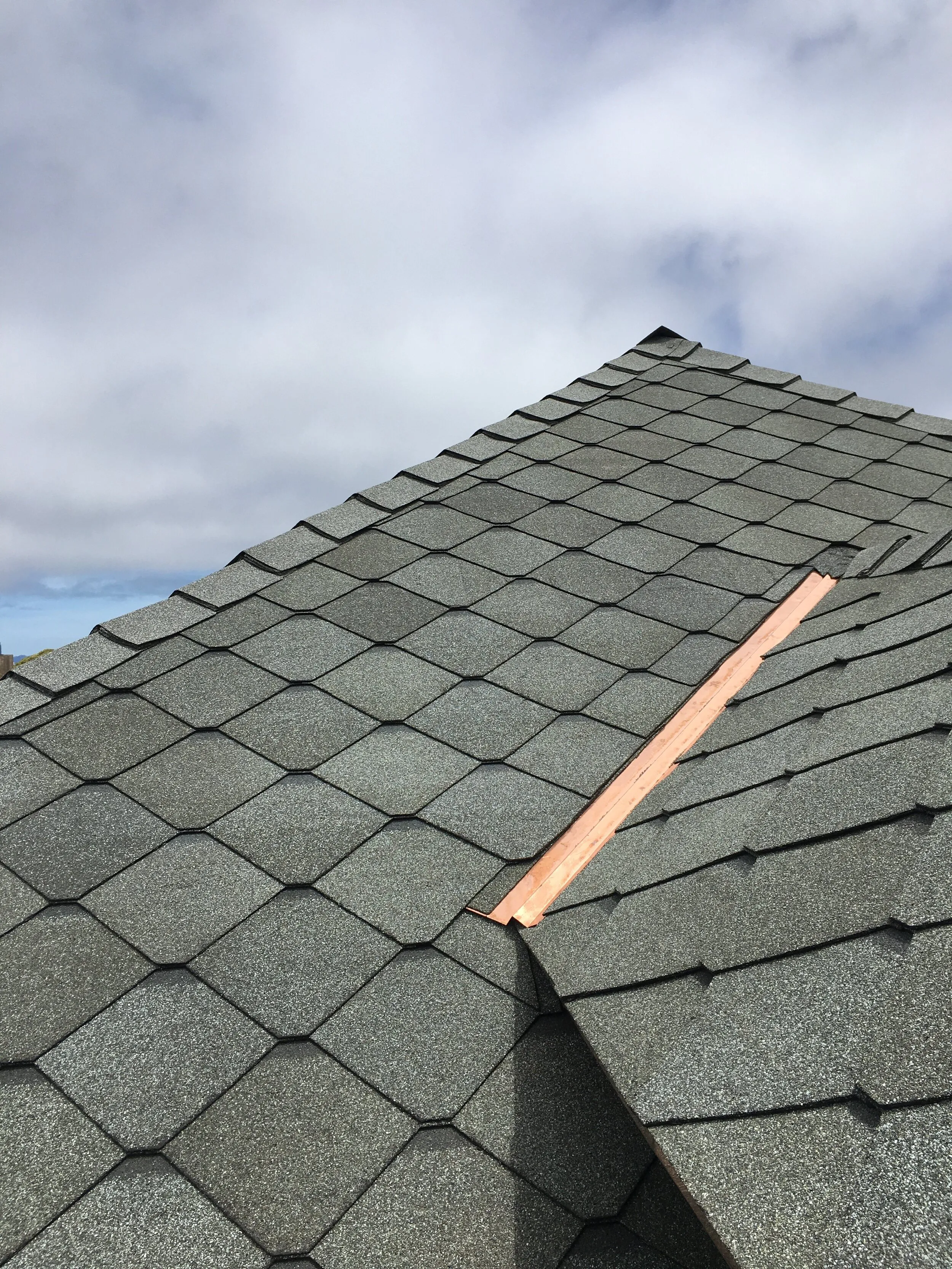 "A newly shingled roof with a clear sky backdrop, installed by Sure Roofing & Waterproofing in San Francisco."