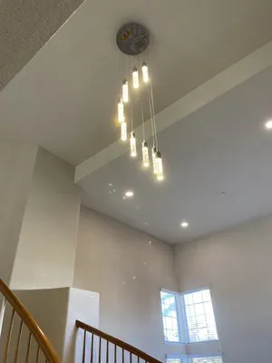 Modern hanging light fixture installed in a high-ceiling room, showcasing innovative design by TD West Electric, Inc. in Union City.