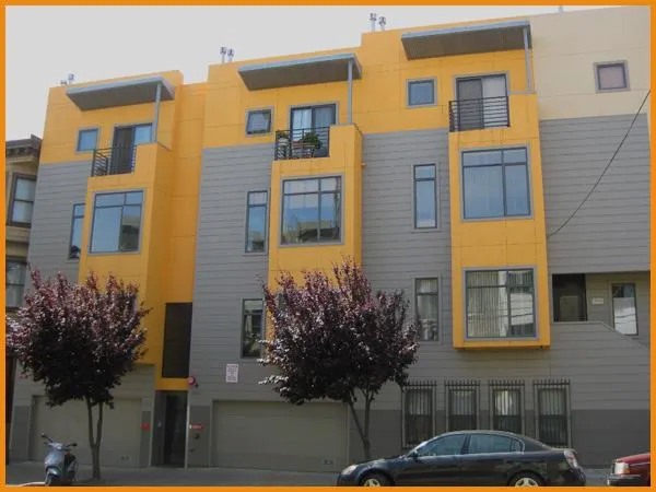 A modern apartment building in San Francisco, featuring a newly painted exterior with vibrant yellow and gray colors, showcasing the work of Tara Pro Painting, Inc.