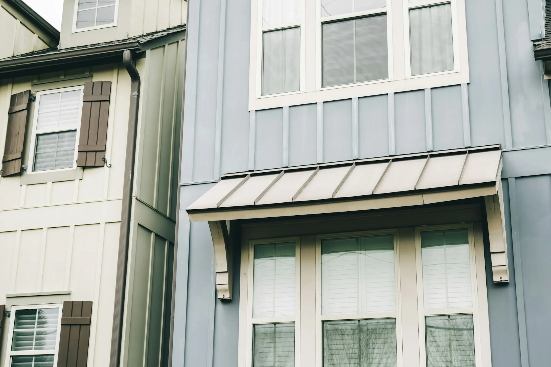 Close-up of a modern building façade featuring blue paneling and white-framed windows, showcasing contemporary architectural elements by The Window Design Studio in Petaluma.