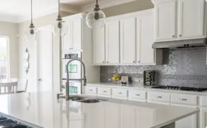Modern kitchen with white cabinetry, an island countertop, stainless steel appliances, and pendant lighting, designed by Thompson Construction, Inc. in Healdsburg.