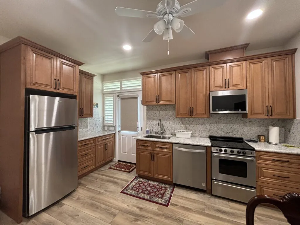 A modern kitchen featuring wooden cabinets, stainless steel appliances, and marble countertops, designed by Today'sKitchen&Bath in Livermore.