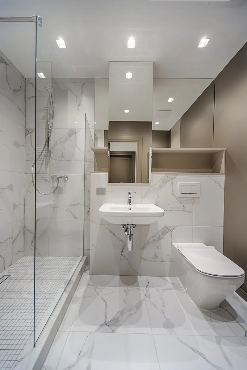 Modern bathroom featuring a glass-enclosed shower, sleek sink, and toilet with marble tile design by TrueNorthKitchen&Bath in SanMateo.