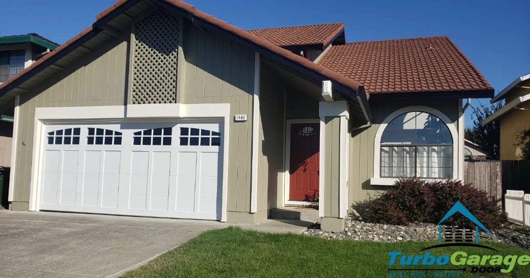 A house with a beige exterior and a red tiled roof, featuring a white garage door with windows, representing Turbo Garage Door in Santa Rosa.