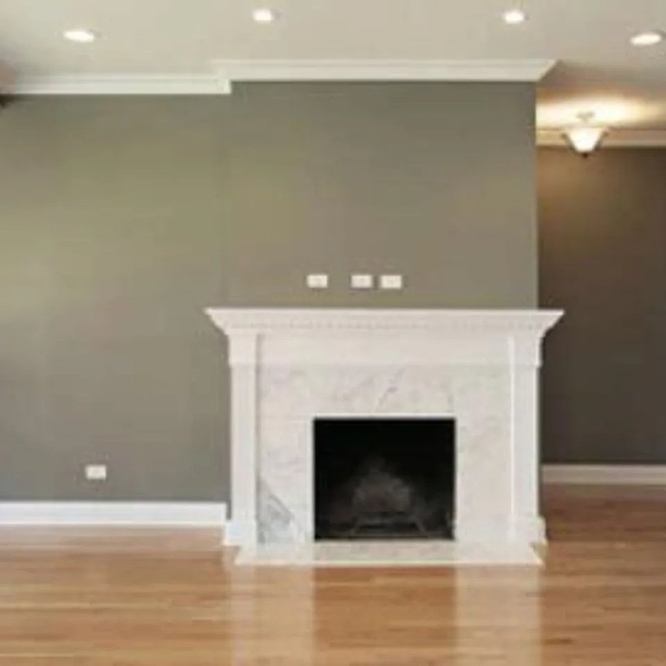 A tastefully painted room featuring a gray wall with a white marble fireplace, showcasing the work of Unique Painting Services in Novato.