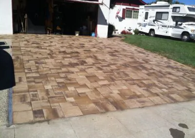 A driveway with neatly arranged rectangular and square pavers in front of a garage, showcasing Unique Pavers' work in San Jose.