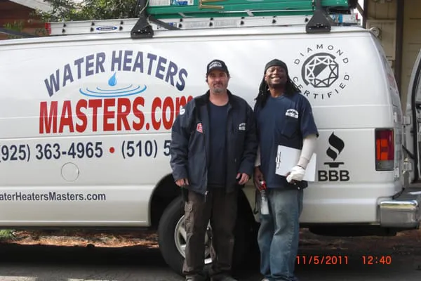 Two technicians standing in front of a Water Heaters Masters Inc. service van in Vacaville.