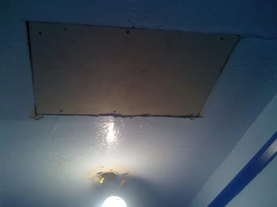 An image of a ceiling with a patched area and a light bulb below, showcasing the repair work done by We Love Small Jobs Handyman Services-Remodelers & Builders in Oakland.