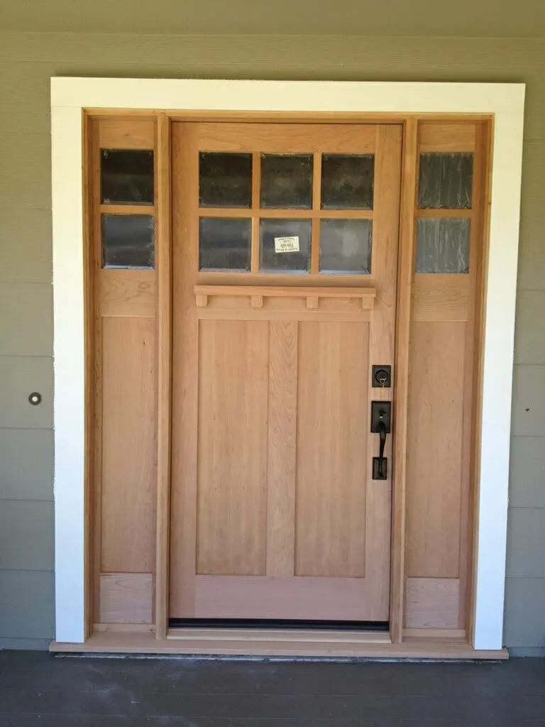 A wooden front door with side panels and glass inserts, designed and installed by West Coast Windows and Doors, Inc. in Concord.