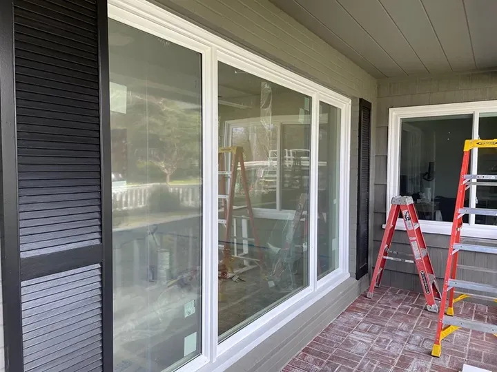 A view of newly installed large windows with a white frame, accompanied by ladders, showcasing the work by West Coast Windows and Doors, Inc. in Concord.