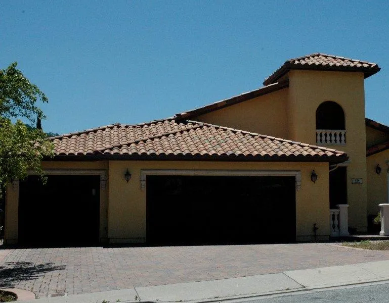 "A house with a tiled roof under a clear blue sky, showcasing the work of Westshore Roofing, Inc. in San Jose."