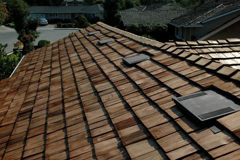 A rooftop with neatly installed wooden shingles in San Jose by Westshore Roofing, Inc., showcasing ventilation panels and expert craftsmanship.