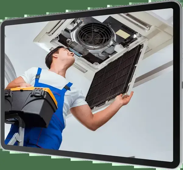 "Technician in blue overalls inspecting a ceiling air conditioning unit with a toolbox, representing Wightons Plumbing, Heating, & Air Conditioning in San Luis Obispo."