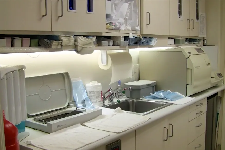 A clean and organized dental sterilization area featuring cabinets, a sink, and sterilization equipment at William M. Schneider, D.D.S. in Walnut Creek.