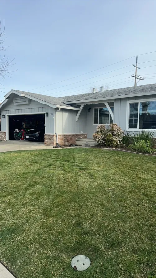 A suburban house in Livermore with a well-maintained lawn, showcasing the roofing work by Yorkshire Roofing of Northern California Inc. DBA Roofmax.